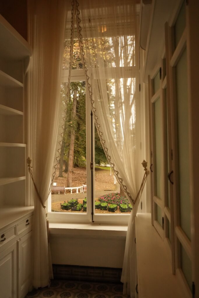 Charming hallway view with elegant curtains and garden scenery outdoors.